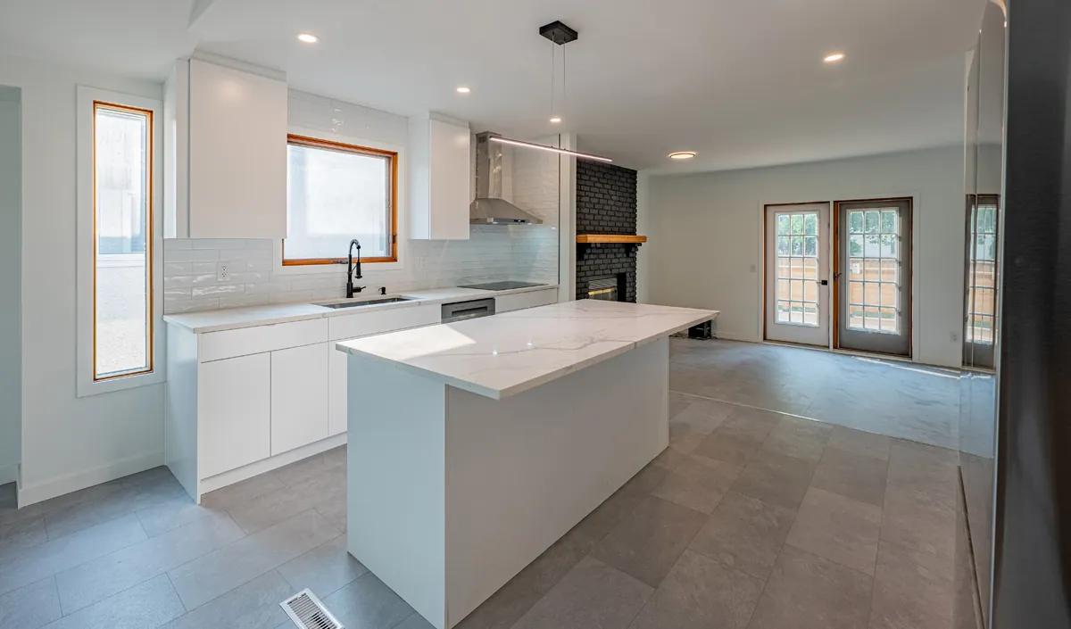 White kitchen with island and brick feature wall